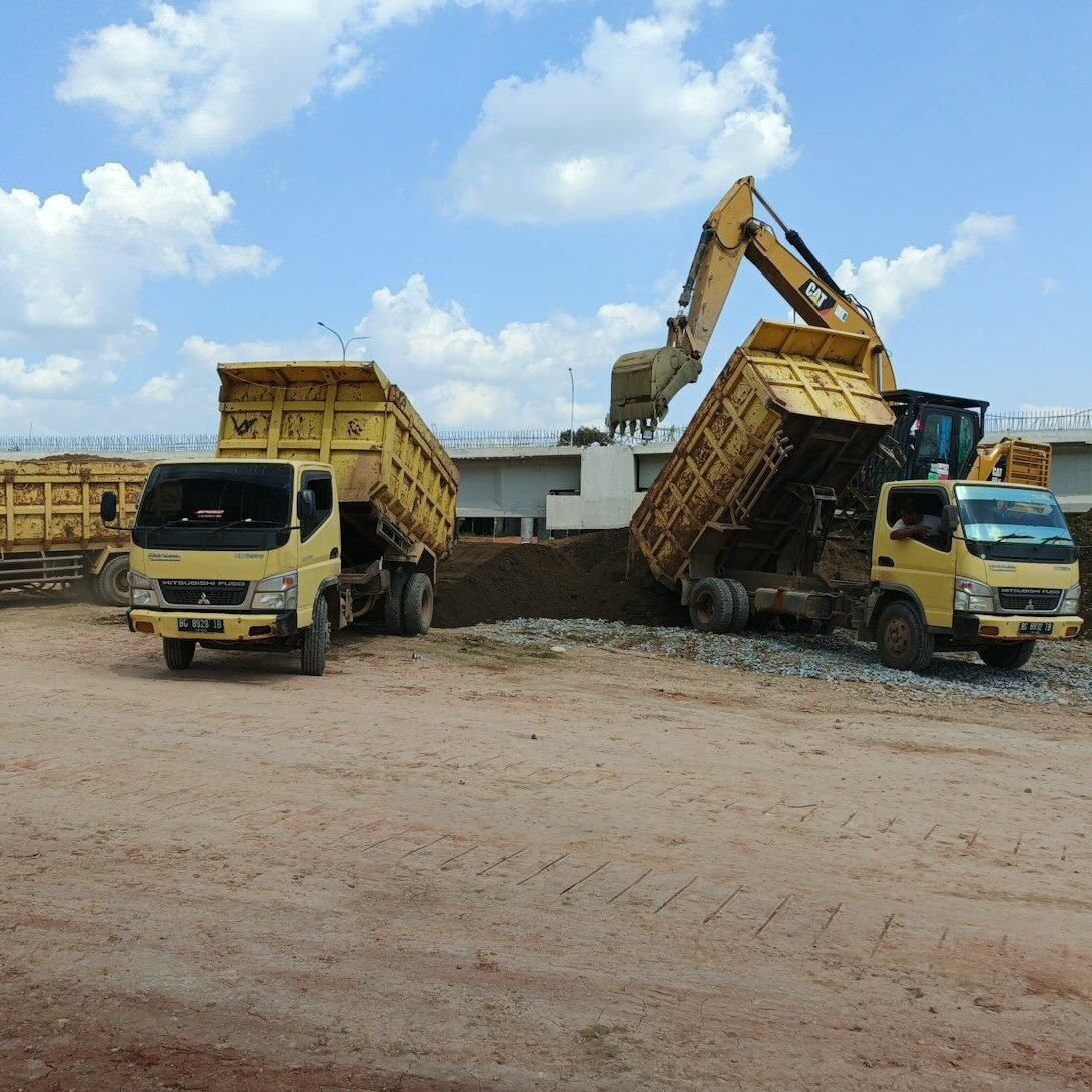 A group of dump trucks parked next to each other